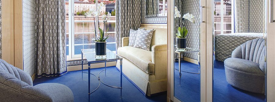 Elegant river cruise suite with floor-to-ceiling windows